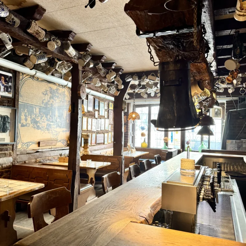 ÄU's Gasthaus - Traditioneller Innenbereich mit Theke und Krügen an der Decke