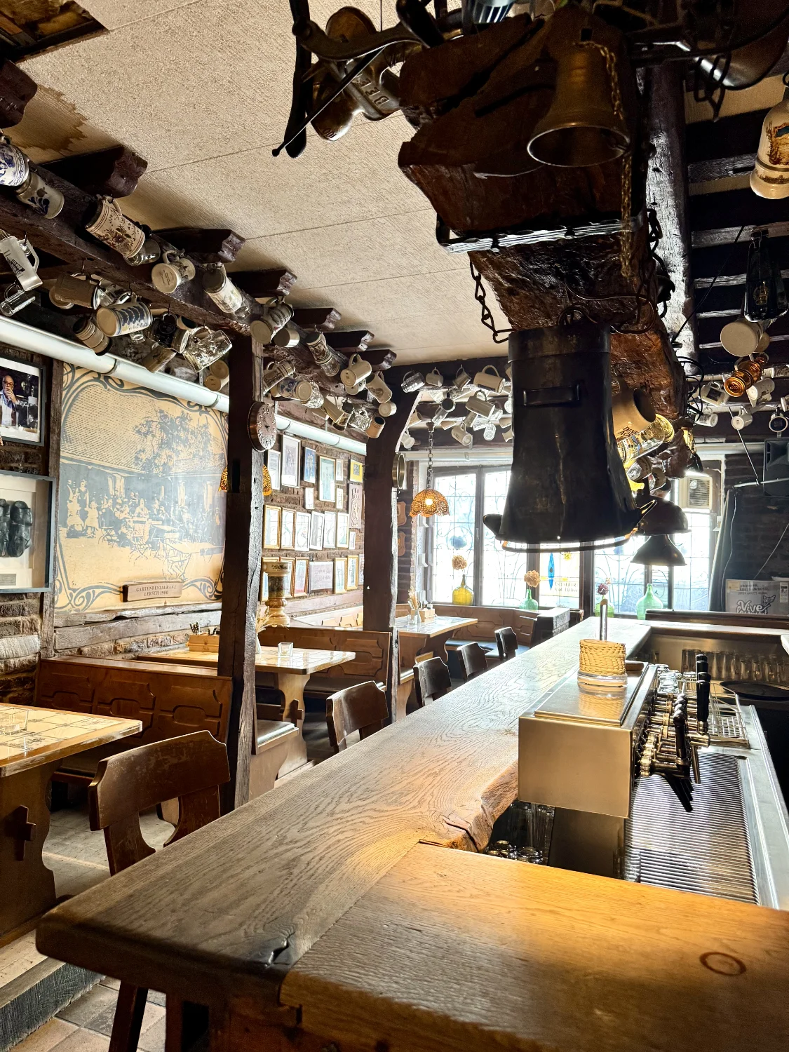 ÄU's Gasthaus - Traditioneller Innenbereich mit Theke und Krügen an der Decke